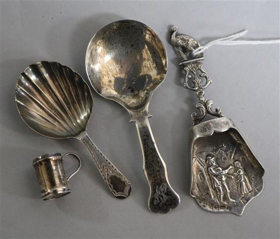 A Georgian silver caddy spoon, two later caddy spoons and a miniature mug.